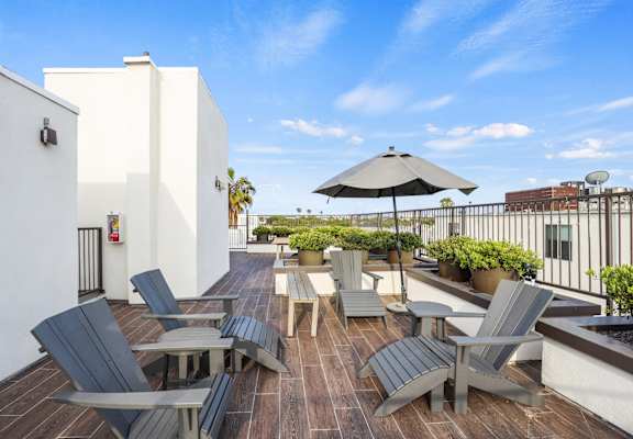a patio with chairs and an umbrella on a roof