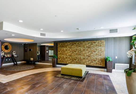 the lobby of a hotel with a yellow couch in the center