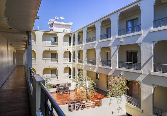 a view of the outside of a building with a courtyard and benches