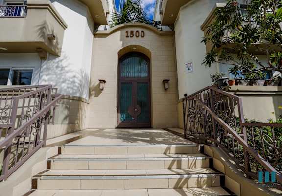 the front of a building with a blue door and stairs