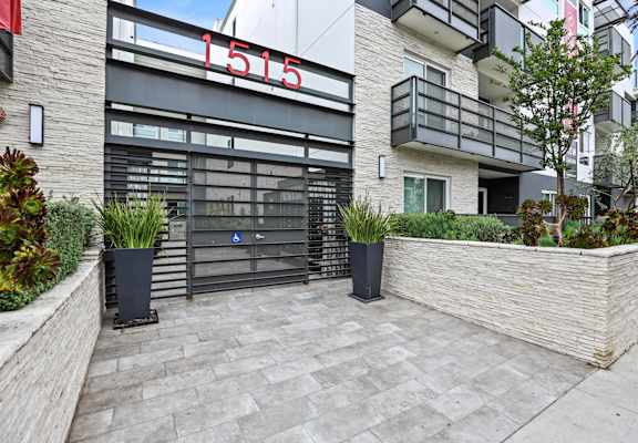 a view of the entrance to a building with a large glass door and a brick wall with