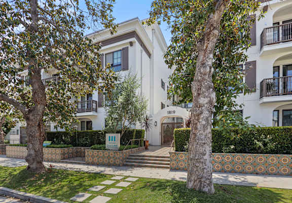 a white apartment building with trees in front of it