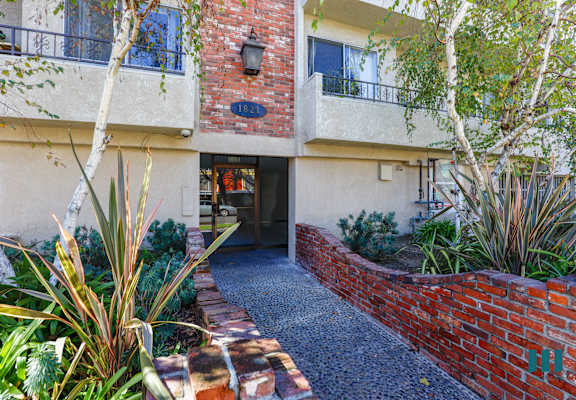 the entrance to a building with a brick wall and a courtyard