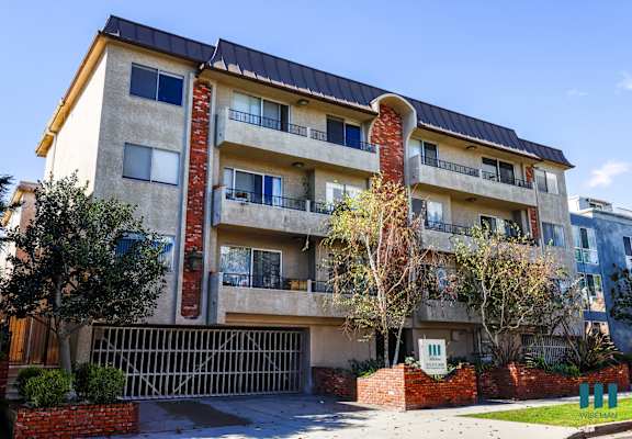 an apartment building with a driveway and a gate in front of it