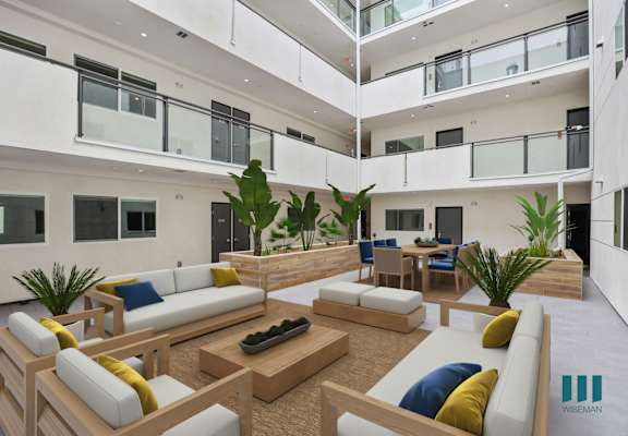 a view of the communal area of a building with white walls and balconies