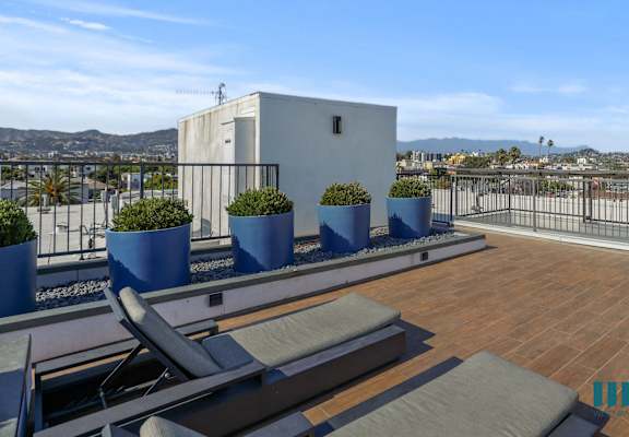 a roof terrace with lounge chairs and a view of the city