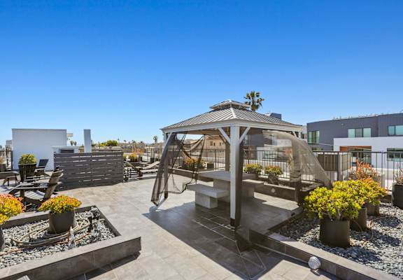 a gazebo on the roof of a building with a blue sky in the background