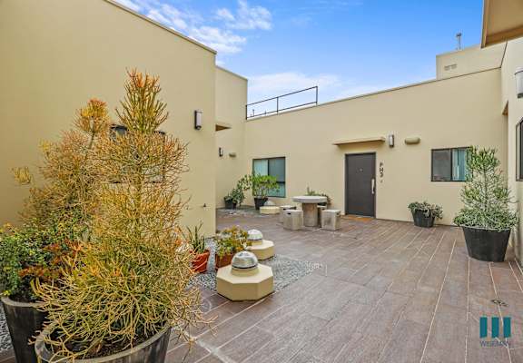 the courtyard of a house with a patio and potted plants