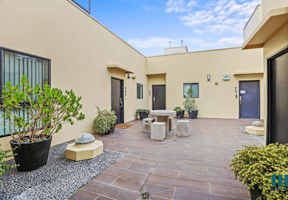 a patio with a table and chairs in front of a house