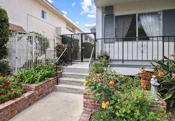 the front yard of a house with a patio and flowers