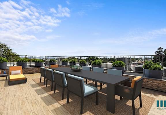 a communal terrace with a table and chairs on a rooftop