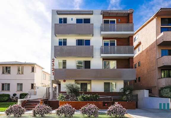 an apartment building with balconies and a street in front of it