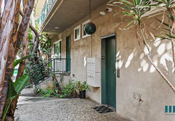 A building with a green door and a balcony with a metal railing.
