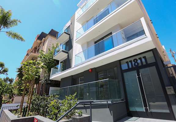a condo building with a glass door and a black and white facade