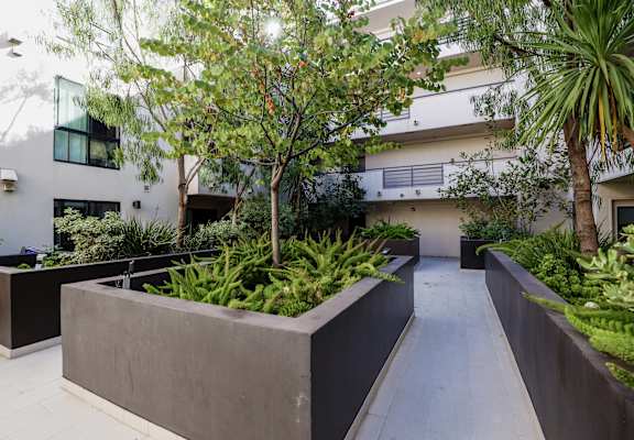 a large concrete planter in front of an apartment building