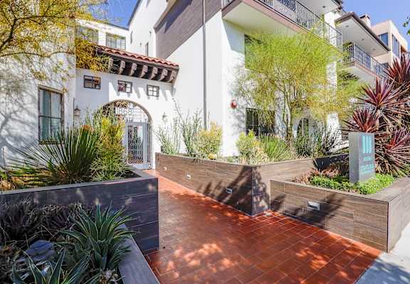 the front yard of a house with a courtyard and plants