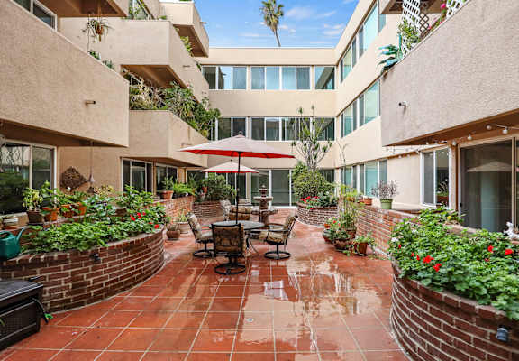 a patio with a table and chairs in a courtyard