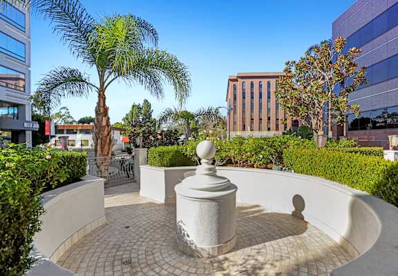 a courtyard with palm trees and a fountain