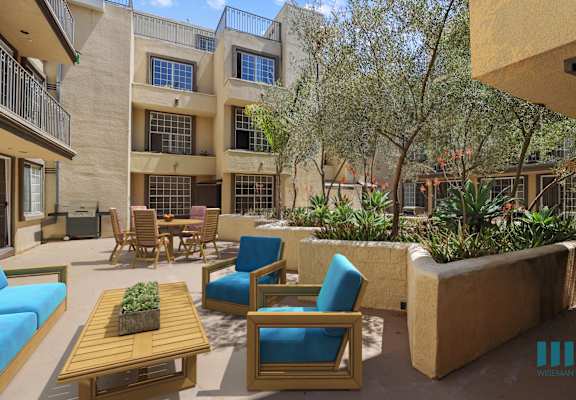 a patio with blue chairs and a wooden table