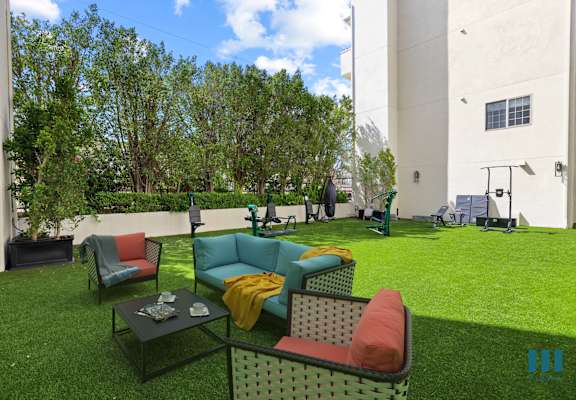 a lounge area with couches and chairs on the grass