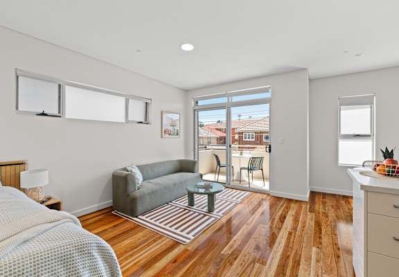 A bedroom with a bed, a couch, a chair, and a table.