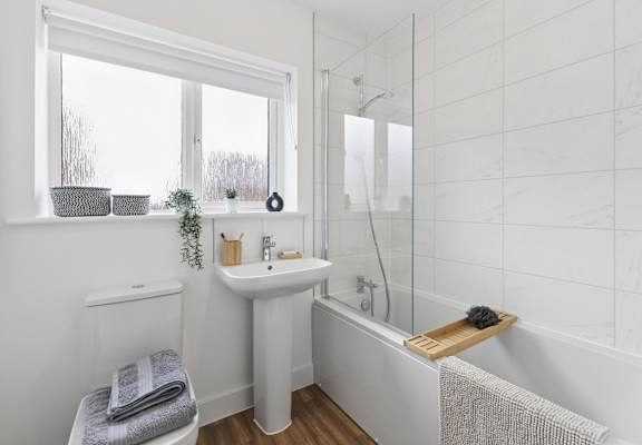A white bathroom with a sink, toilet, and bathtub.