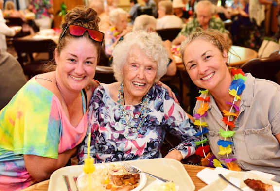 two elderly women sitting at a table with a bottle of wine at River Commons Senior Living, Redding, 96002