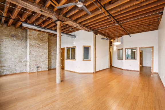 a large living room with a brick wall and wood floors