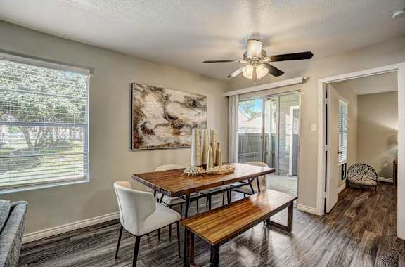 A dining room with a wooden table and chairs.