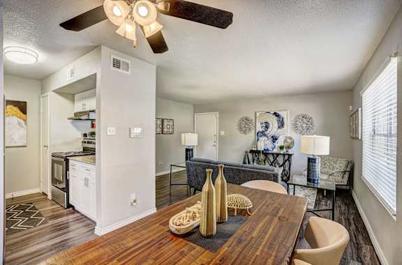 A modern dining room with a wooden table and chairs.