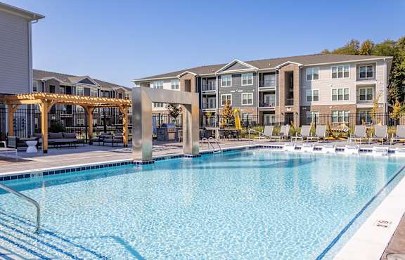 a rendering of an apartment complex with people playing in the yard at The Warren, Jeffersonville, IN, 47130