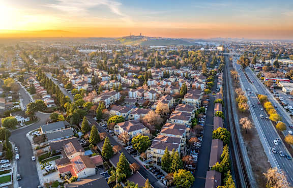A sunset view of a city with a highway running through it at The Woods Apartments, San Jose, California