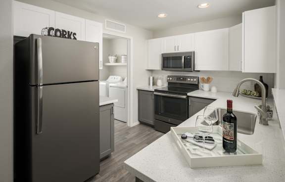 A modern kitchen with a white island and stainless steel appliances.