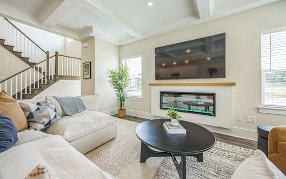 A living room with a white couch and a black coffee table.