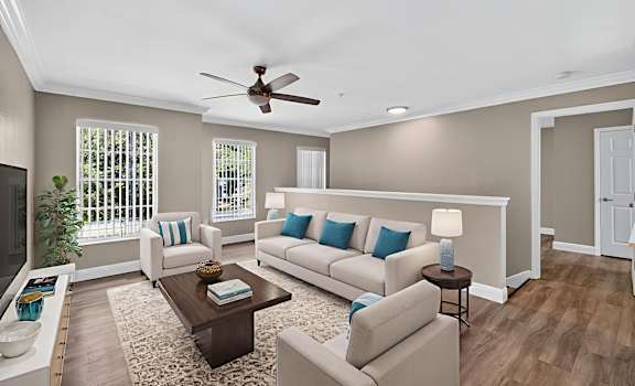 A living room with a white couch and a brown coffee table.