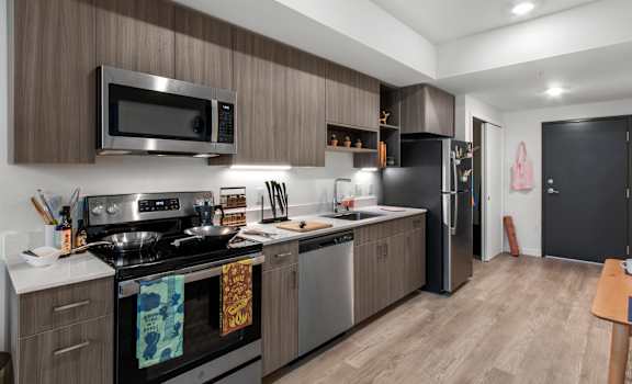 A modern kitchen with a stove top oven and a microwave above it.