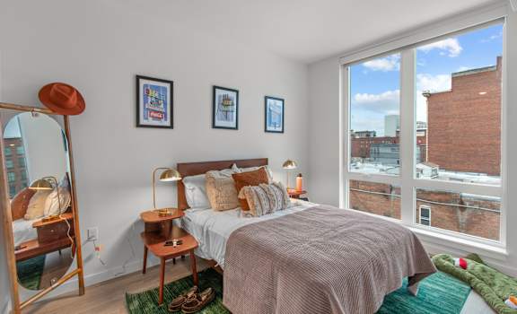 A bedroom with a large bed and a view of the city.