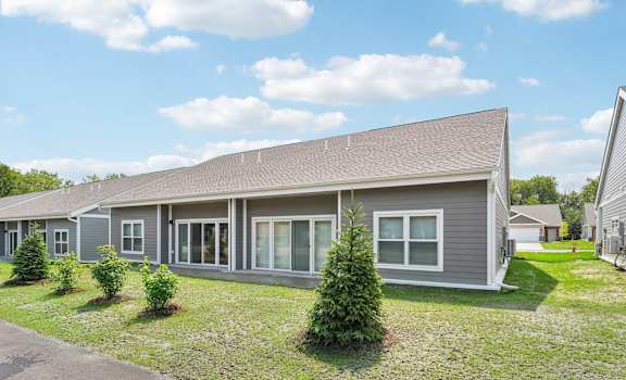 a gray house with a yard in front of it