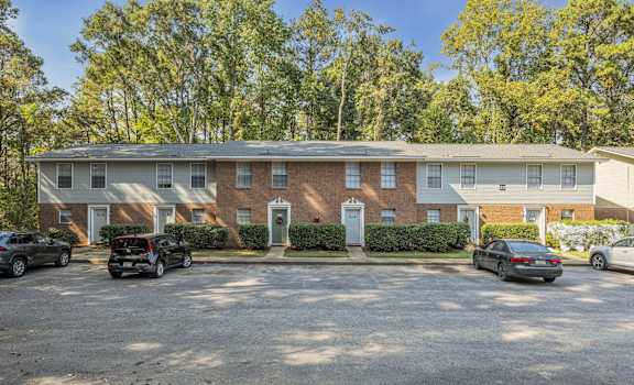 a brick apartment building with cars parked in front of it