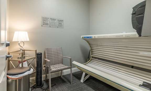 a patient room with a bench and a table with a lamp and a chair