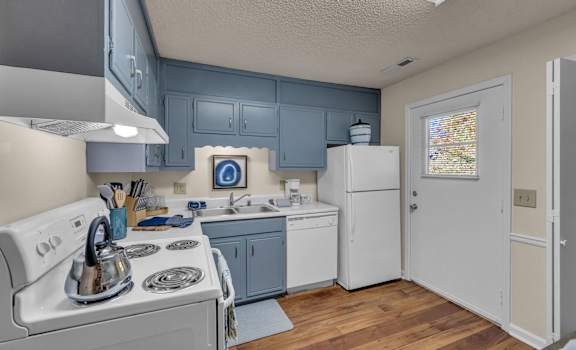 a kitchen with white appliances and blue cabinets