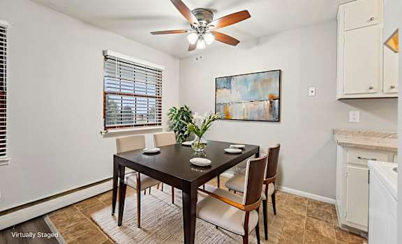 A dining room with a table and chairs.