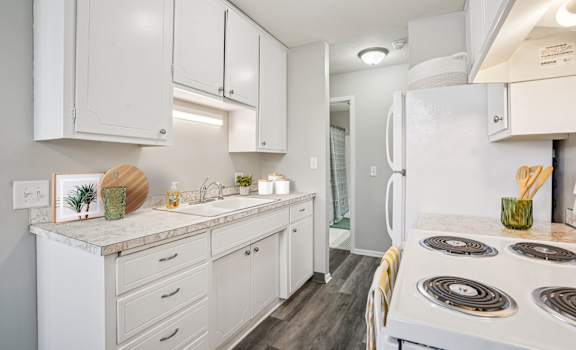 A white kitchen with a stove top oven.