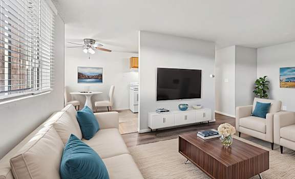 A living room with a white couch and a wooden coffee table.
