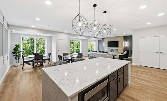 A modern kitchen with a large island and pendant lights.