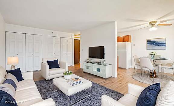 A living room with white furniture and a flat screen TV.