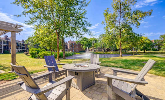 A patio with a table, chairs, and a fountain.