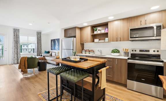 an open kitchen and living room with a table and chairs at The Mill on Maple Apartments, Oregon City, OR 97045