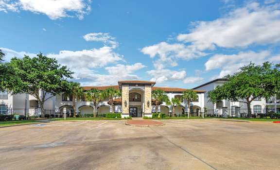 a large parking lot in front of a building with trees