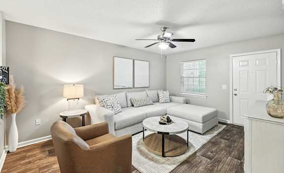 A living room with a brown chair and a white couch.